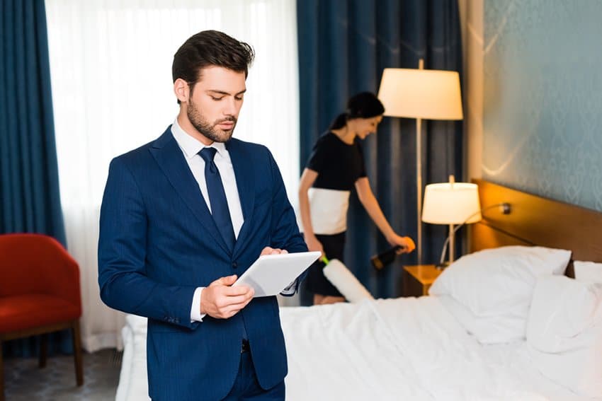 business man in hotel room with smart tablet