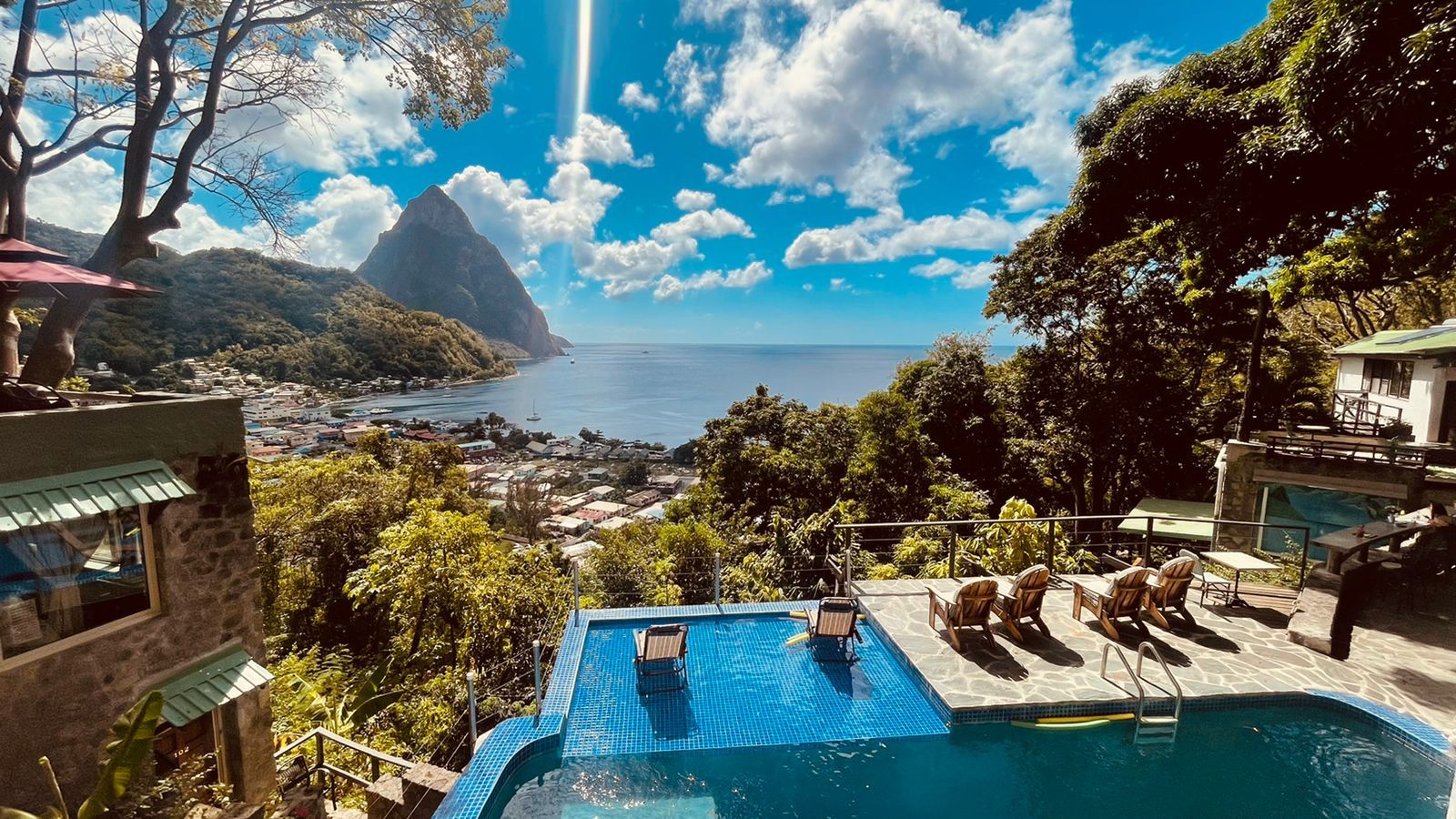 scenic image of a mountainous view and the ocean with an infinity pool closer to the foreground